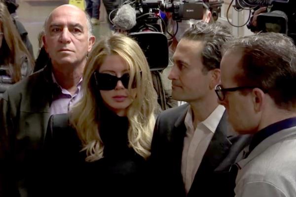 Khazar Elyassnia in dark sunglasses and coat 
